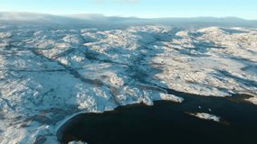 Drone shows the snowy shoreline of Motovsky Bay along Kola Peninsula in Russia, with frozen waters of the Barents Sea under Arctic conditions. - Powered by Shutterstock - Get 15% off with code: PIKWIZARD15