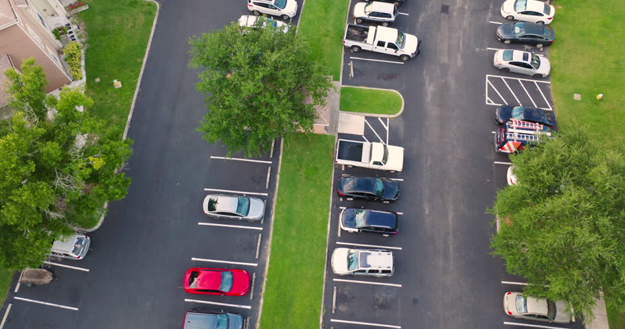 Cars lined up in designated parking spaces outside new Florida condominiums in suburban neighborhood setting.
