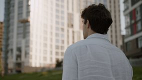 Back view happy Caucasian European young successful handsome man going steps walking male smiling looking around tourist guy businessman business outdoors city urban student walk at street joyful move - Powered by Shutterstock - Get 15% off with code: PIKWIZARD15