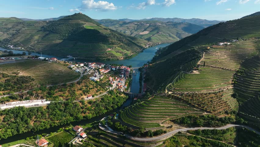 Pinhão, Portugal - Picturesque aerial of Pinhão village along the Tua River, surrounded by dramatic terraced vineyards in the Douro Valley