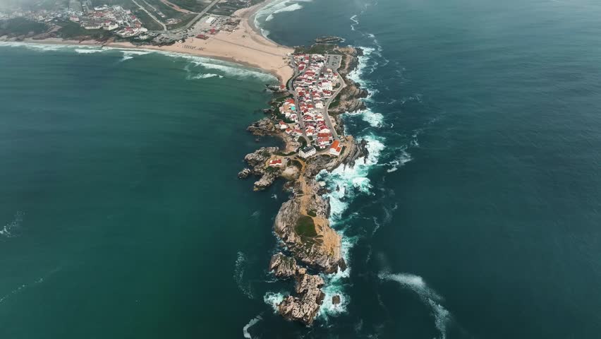 Aerial view of red-roof town of Baleal, sandy beach and misty skyline