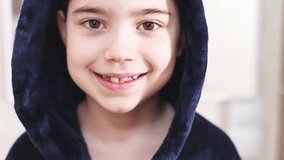 kid in bathroom in bathrobe looking in mirror and smiling. boy combing wet fresh washed hair.preschooler boy with front permanent teeth in rising.daily routine hygiene. child with hood on head. - Powered by Shutterstock - Get 15% off with code: PIKWIZARD15