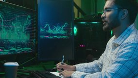 Indian Arabian man writing notes notebook working with pc computer trader programmer coder hacker male complete finish work online businessman night business office ethnic guy stretch hands relaxing - Powered by Shutterstock - Get 15% off with code: PIKWIZARD15