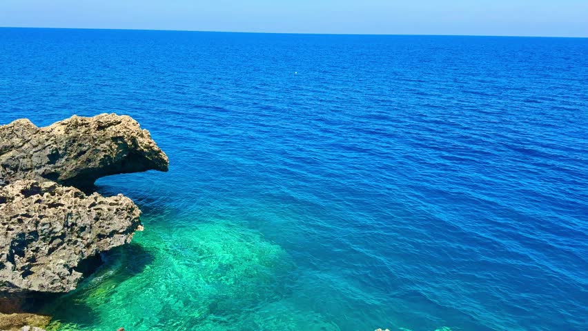Picturesque beach, waves crashing on the sandy shore. Sea waves beat against the rocks. Cyprus Island, Mediterranean Sea.