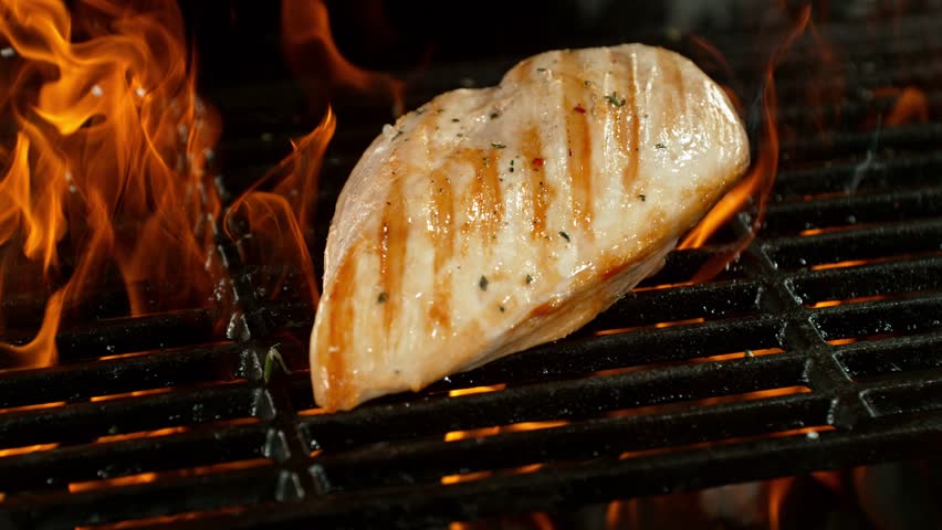 Super Slow Motion of Delicious Chicken Breast Fillets on a Grill with Roaring Flames