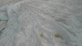Striking terraces of Pamukkale, Turkiye, Turkey in drone retreat. Layers of calcium deposits form surreal steps with yellow hues and water pools - Powered by Shutterstock - Get 15% off with code: PIKWIZARD15