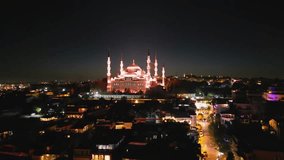 A fast aerial approach zooms toward the luminous Blue Mosque. The pink-lit domes rise prominently as the cityscape converges into the heart of historic Istanbul. - Powered by Shutterstock - Get 15% off with code: PIKWIZARD15