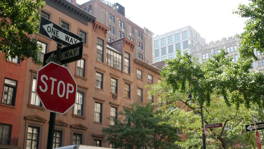 New York City oneway crossroad, Stuyvesant street intersection one way arrow. Manhattan Midtown residential building architecture, United States real estate. Red brick house wall, red stop road sign.