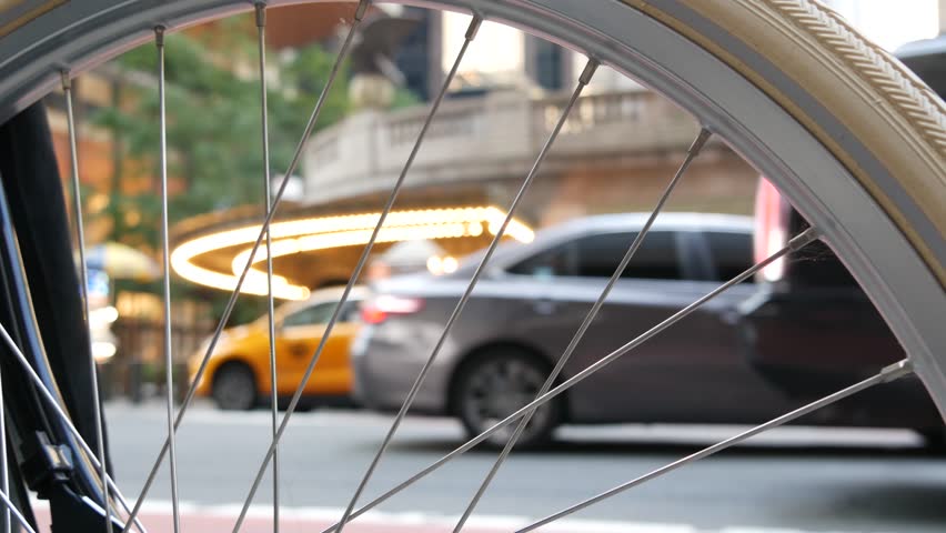 New York City Grand Central Terminal railway station, 42 street. Manhattan Midtown. Yellow taxi cabs, car transport on Pershing Square, NYC, USA. American urban road traffic, people thru bike wheel.