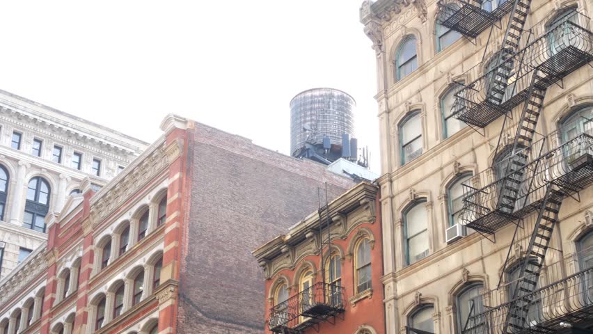 New York City Manhattan Soho fashion district near Broadway street. USA urban building facade, old classic american architecture. Residential real estate in NYC United States. Water tower tank on roof