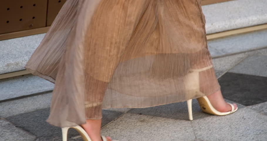 asian woman walking along the beach looking at the beauty of phu quoc island in vietnam on the kissing bridge long beige dress white handbag beautiful young lady with black hair