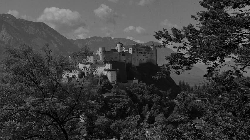 Vintage film-stylised black and white Video of Salzburg city in Austria. Castle with the mountains in the background.