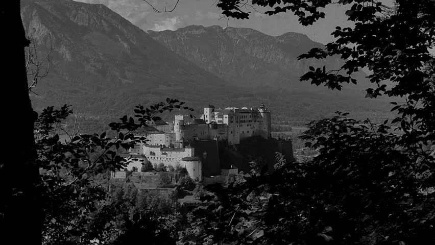 Vintage film-stylised black and white Video of Salzburg city in Austria. Castle with the mountains in the background.