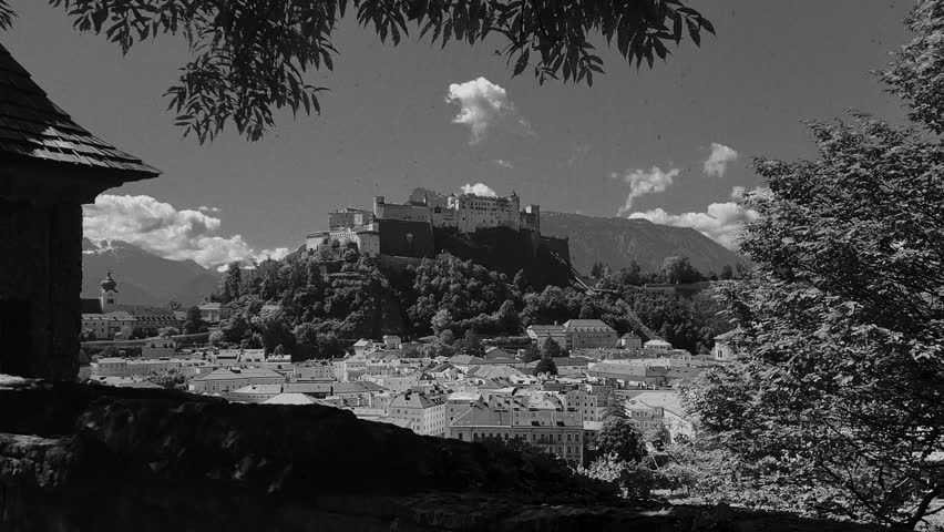 Vintage film-stylised black and white Video of Salzburg city in Austria. Castle with the mountains in the background.