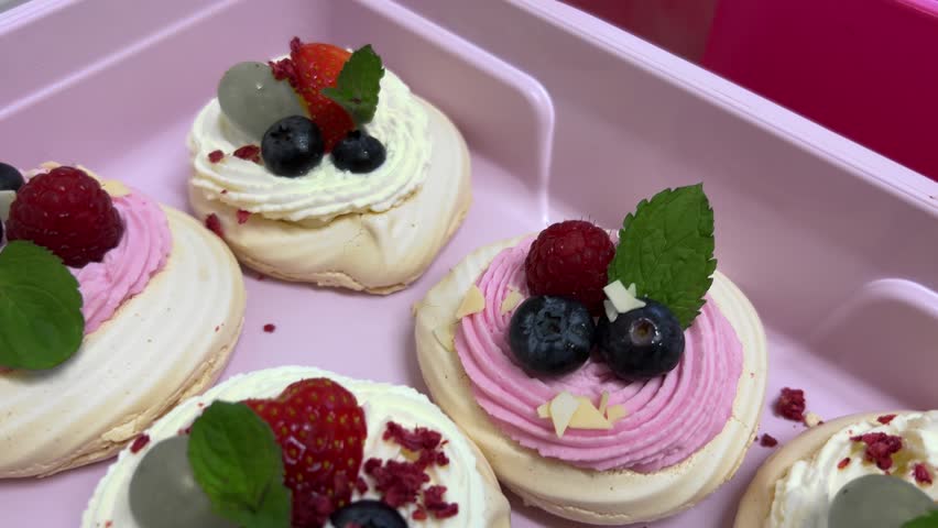 Mini Pavlova Cakes on Pink Background, Moving Top View