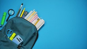 School bag and school supplies moving out of it on blue background. Back to school concept. Stop motion - Powered by Shutterstock - Get 15% off with code: PIKWIZARD15