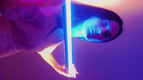Vertical video. Futuristic posing. Neon girls. Young women move with glowing bright decorative LED tubes. Nightlife lighting of models performance. - Powered by Shutterstock - Get 15% off with code: PIKWIZARD15