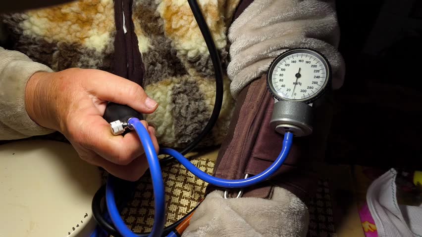 A person holding a blood pressure gauge in their hand.
