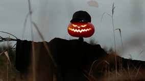 Spooky Jack-o'-Lantern Scarecrow with Glowing Face in Dark Outdoor Field at Dusk - Powered by Shutterstock - Get 15% off with code: PIKWIZARD15