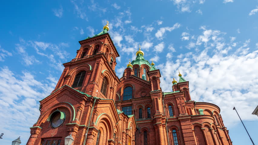 Uspenski cathedral in Helsinki Finland hyper lapse - time lapse of Christian Orthodox religion church made of red brick showcasing magnificent architecture. Historical temple in setting sun light.