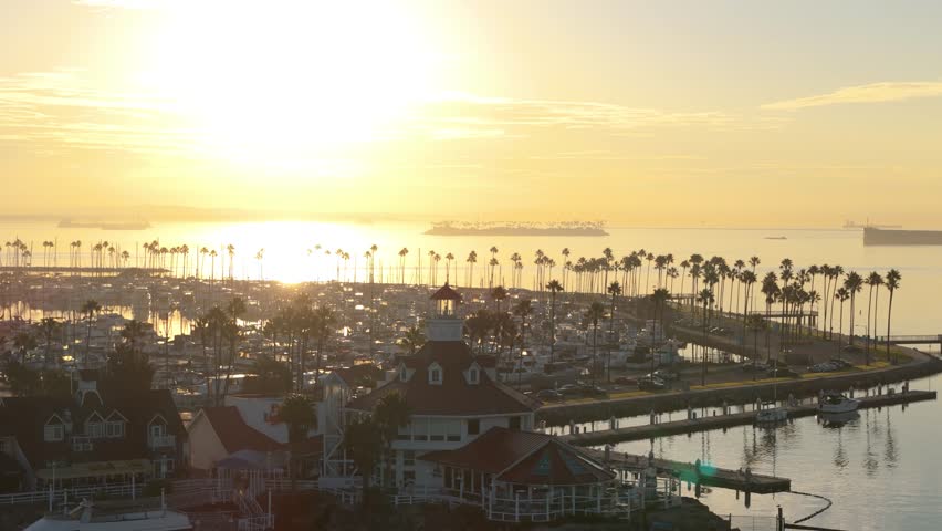 Aerial view of Lions Lighthouse at sunrise, revealing calm waters and distant ships in Long Beach, California.