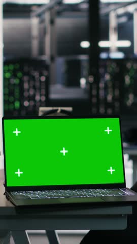 Vertical video Chroma key laptop and desktop PC used for visualizing AI workloads and inspecting server room layout. Green screen notebook supporting artificial intelligence systems through simulated