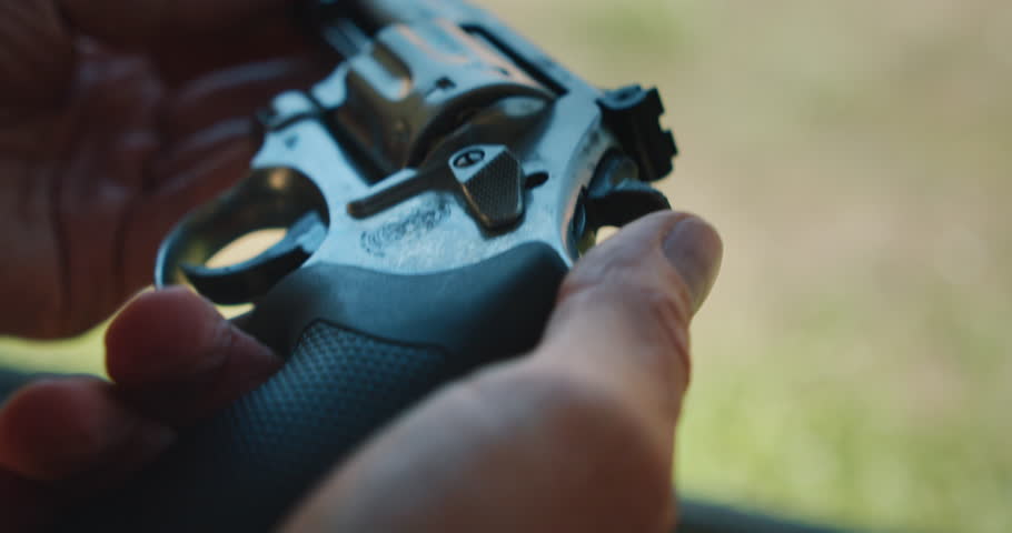 Close-up of revolver held during firearm practice at shooting range outdoors
