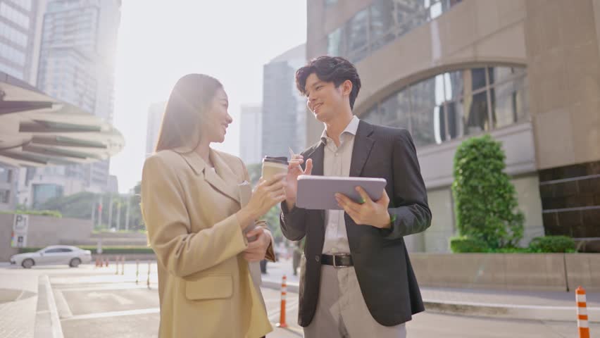 Asian young businessman and woman partner working outdoors in city. Attractive colleagues employee people feel happy and relax while spend free leisure time standing outside office company together. - Powered by Shutterstock - Get 15% off with code: PIKWIZARD15