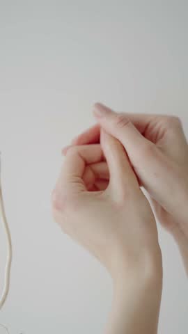 Close-up of hands with an elegant manicure, gently massaging each other, set against a clean, white background. The image conveys relaxation, self-care, and beauty.