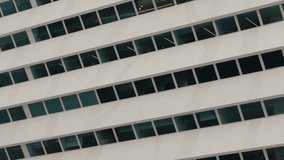 Close-up view of a modern building facade with a pattern of geometric windows in an urban setting, showcasing contemporary architectural design.Contemporary Office Building Facade with Rows of Windows - Powered by Shutterstock - Get 15% off with code: PIKWIZARD15