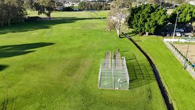 Aerial footage of cricket practice at a lush park in Gold Coast, Australia, captured in bright daylight with clear skies - Powered by Shutterstock - Get 15% off with code: PIKWIZARD15