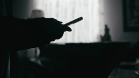 Silhouetted man texts message in Dark room backlit by veiled curtains - Powered by Shutterstock - Get 15% off with code: PIKWIZARD15