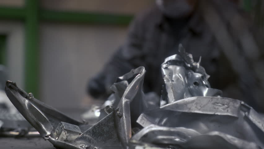 Men workers of garbage processing plant sort garbage. Male workers sort and recycle scrap metal. Plastic, polymer household waste is transported on conveyor belt in factory. Ecology of planet. Man