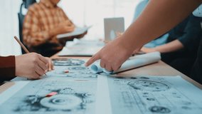 A vibrant team collaborates in a sleek office environment, engaging in a productive discussion over blueprints and digital tools to foster innovative ideas. SACTR - Powered by Shutterstock - Get 15% off with code: PIKWIZARD15