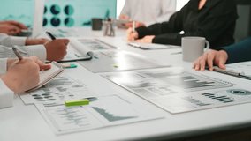 Professionals collaborate at a modern office, analyzing detailed reports and charts to enhance business strategy and performance through focused teamwork and data-driven decisions. SACTR - Powered by Shutterstock - Get 15% off with code: PIKWIZARD15