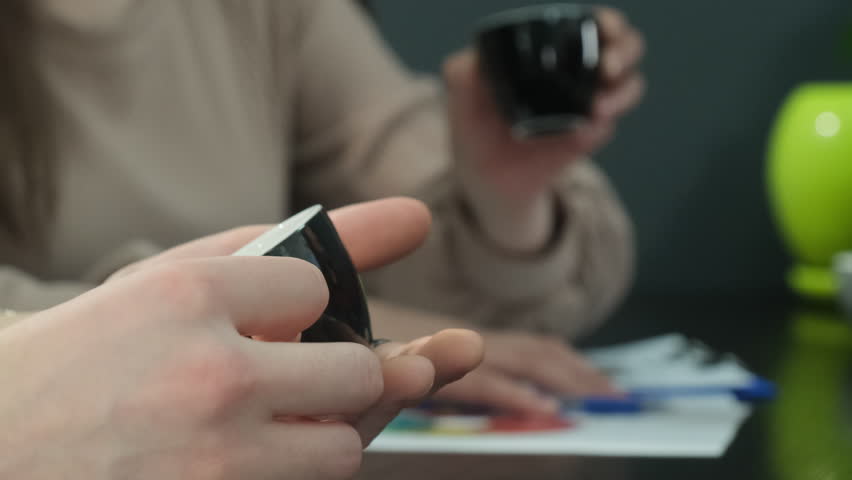 Tasting participants hold cups with samples in hands while listening to lecture about coffee variety. Coffee tasting with professional barista