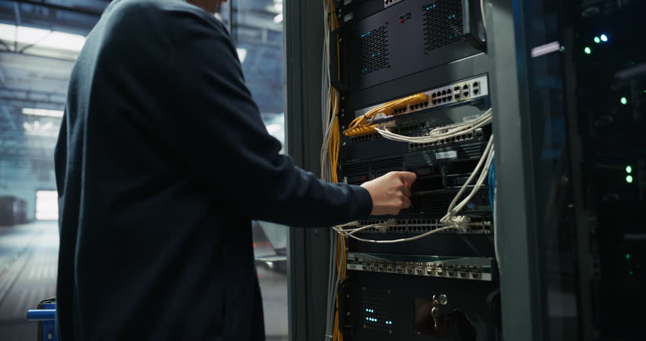Server Technician Installing Additional Hardware into a Server Cabinet in a Data Center. Anonymous Specialist Inserting Hard Drives in Order to Increase Storage, Memory and Compute Power