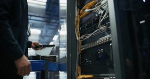 Anonymous IT Engineer Installing New Hard Drives and Other Hardware into a Server Rack System in a Data Center. IT Specialist Doing Maintenance, Running Diagnostics and Updating Equipment. Low Angle - Powered by Shutterstock - Get 15% off with code: PIKWIZARD15