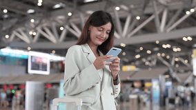 Confident traveler using smartphone at airport terminal, businesswoman smiling while checking flight updates, lifestyle modern working woman travel planning executive checking phone before boarding - Powered by Shutterstock - Get 15% off with code: PIKWIZARD15