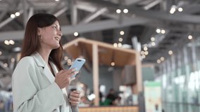 Confident traveler using smartphone at airport terminal, businesswoman smiling while checking flight updates, lifestyle modern working woman travel planning executive checking phone before boarding - Powered by Shutterstock - Get 15% off with code: PIKWIZARD15