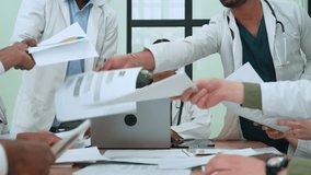 Healthcare professionals experiencing intense workplace stress, throwing medical documents during heated meeting, revealing underlying tension and burnout among diverse medical team - Powered by Shutterstock - Get 15% off with code: PIKWIZARD15