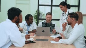 Medical team collaborating, reviewing brain scans and x-rays on laptop, sharing insights during professional healthcare strategy meeting, highlighting interdisciplinary communication - Powered by Shutterstock - Get 15% off with code: PIKWIZARD15