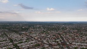 Aerial view of Bensonhurst, Brooklyn in the late afternoon just before a rainstorm. Sunlight breaks through dramatic clouds, casting warm highlights over residential rooftops and tree-lined streets. T - Powered by Shutterstock - Get 15% off with code: PIKWIZARD15