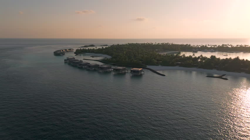 Sunset silhoutte of luxury over water villas on a tropical island in the Maldives