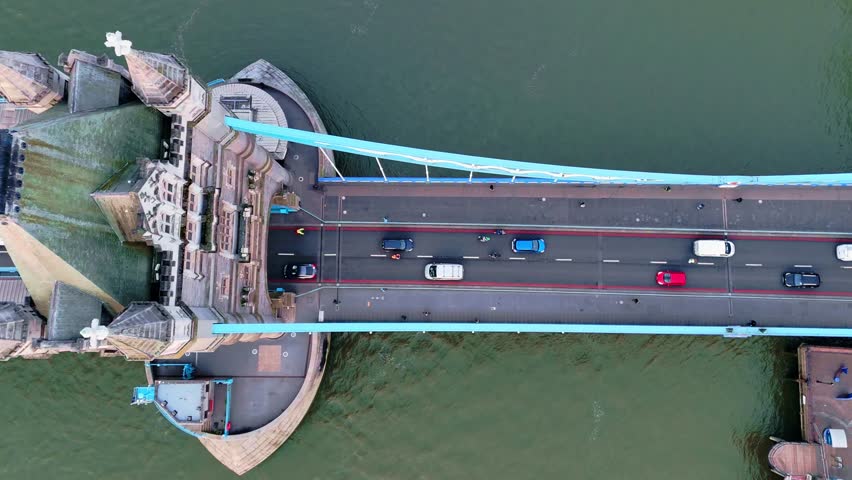 Pedestrians and traffic crossing iconic Tower Bridge, aerial panning