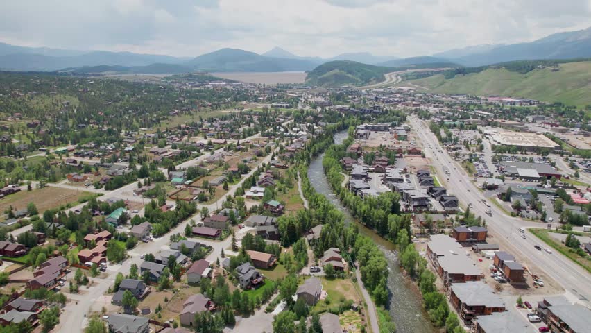 This is a static aerial video of the city of Silverthorne in Colorado. The Blue River is visible as well as part of the city with mountains in the background.