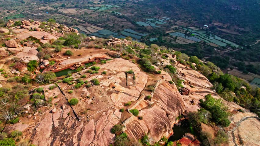 Ancient Rock Fort Hilltop with crop field lands and greenery, day time, semi circle, drone shot, 4k.
