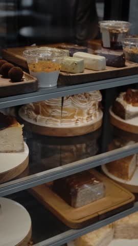 Bakery pastry chef puts a large, creamy, close-up cream cake on display.