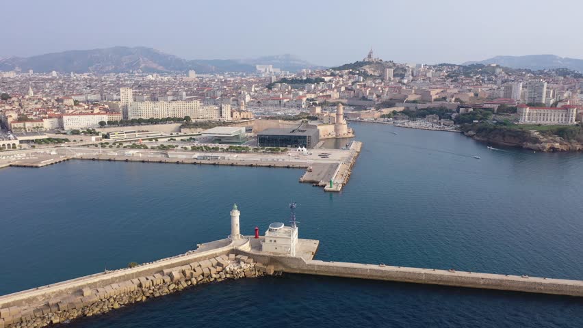 Picturesque drone view of modern Marseille cityscape on Mediterranean coast overlooking large Old Port with moored pleasure yachts and Fort Saint-Jean on sunny day, France
