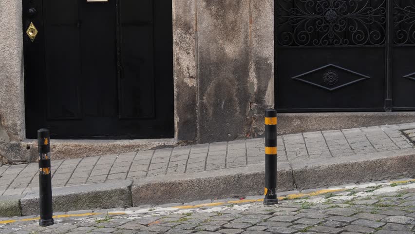 Black entrance with intricate iron gate and traditional Portuguese blue tile detail on old stone wall
